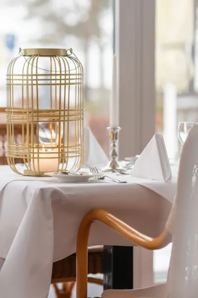 Stilvoll gedeckter Tisch mit warmem Kerzenlicht im Restaurant des Grand Hotels Binz.