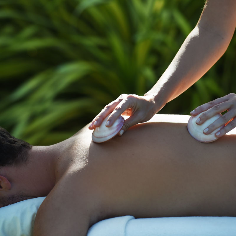 Ganzkörpermassage mit warmen Muscheln und fließenden Griffen zur Lösung von Verspannungen und Förderung des Wohlbefindens.