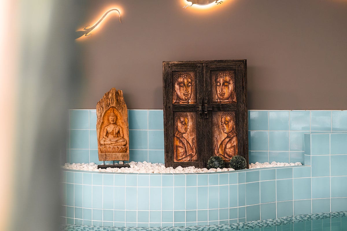 Holzschnitzereien und Buddha Figuren im Poolbereich