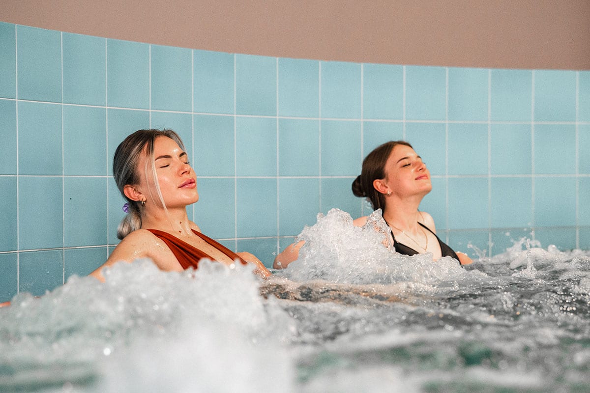 Sprudelbad im Wellnessbereich, Gäste genießen die Massage durch das Wasser